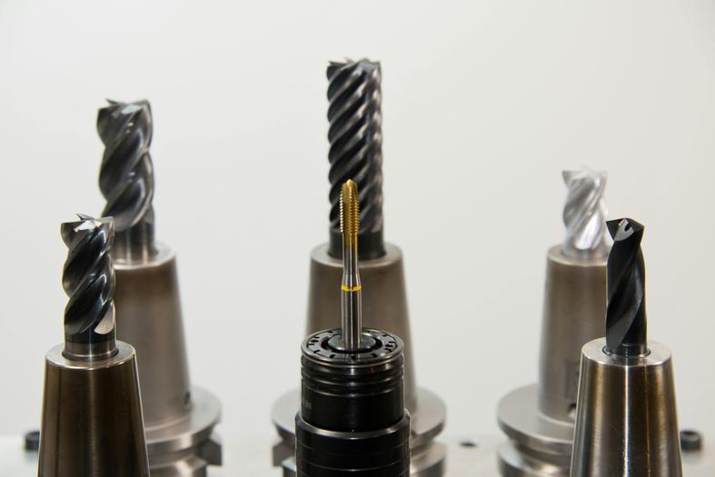 Various CNC cutting tools, including end mills and thread taps, for precision machining