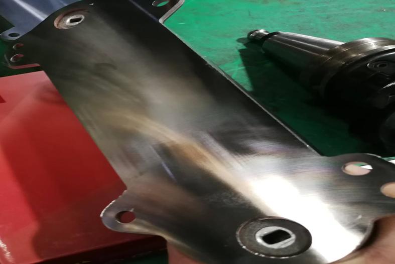 Machined metal plate with smooth surface and precision-drilled holes